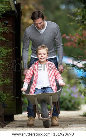 Father Giving Son Ride In Wheelbarrow