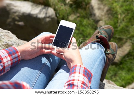 Teenage Girl Using Mobile Phone In Countryside