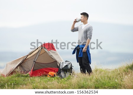 Young Man On Camping Trip In Countryside