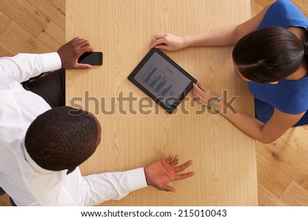Overhead View Of Businesspeople With Digital Tablet At Desk