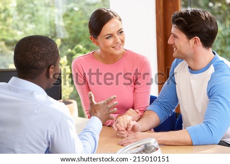 Couple Talking With Financial Advisor In Office