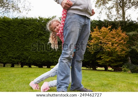 Father And Daughter Playing Game In Garden Together