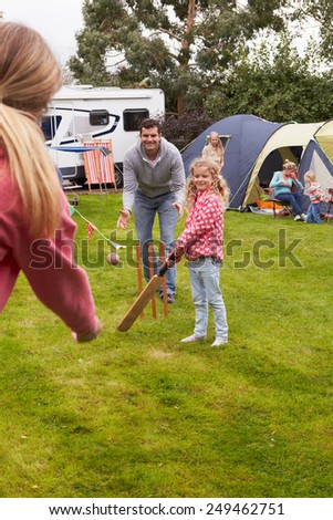 Family Playing Cricket Match On Camping Holiday