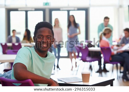 Portrait Of Male College Student Relaxing In Cafeteria