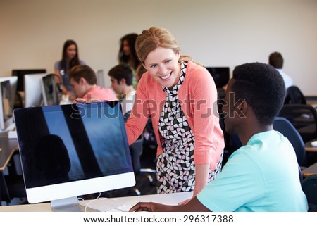 Tutor With Male College Student In Computer Class