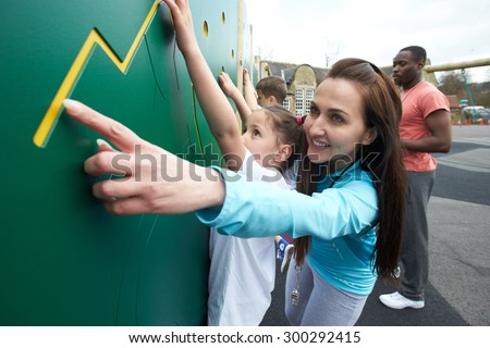 Girl On Climbing Wall In School Physical Education Class