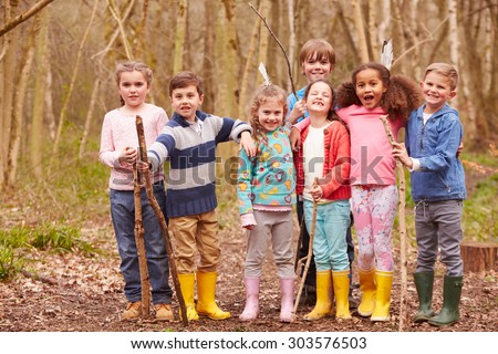 Portrait Of Children Playing Adventure Game In Forest