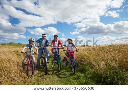 Portrait Of Family Cycling Through Countryside Together