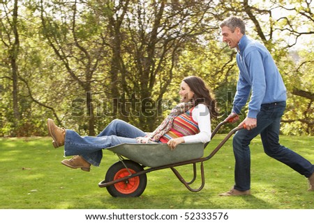 stock-photo-couple-with-man-giving-woman-ride-in-wheelbarrow-52333576.jpg
