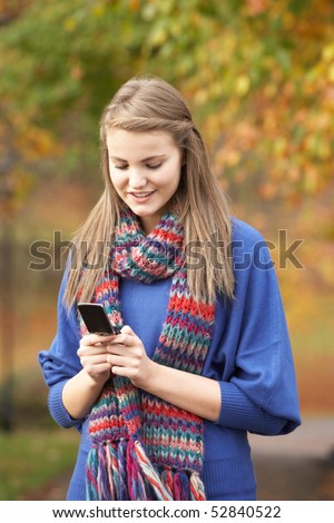 Teenage Girl Making Mobile Phone Call In Autumn Landscape