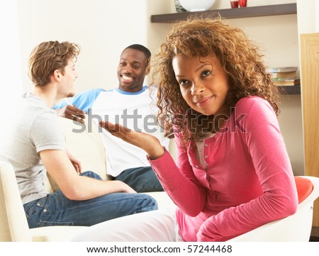 Two Male Friends Chatting Together With Bored Looking Female Partner At Home