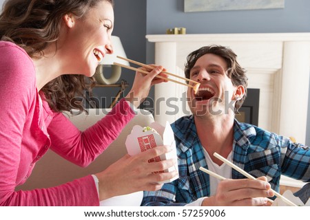 Couple Enjoying Chinese Takeaway Meal At Home