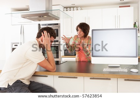 Young Couple Discussing Personal Finances In Modern Kitchen