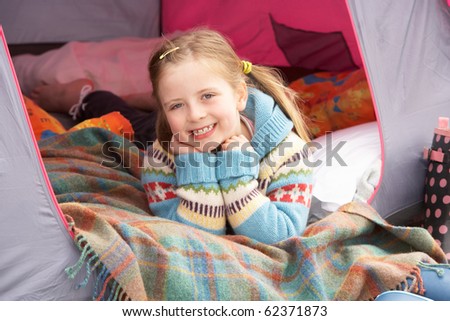 Young Girl Relaxing Inside Tent On Camping Holiday