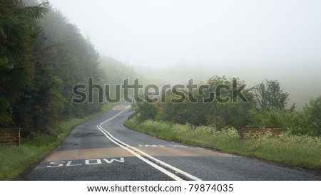 Driving on countryside road in fog. Illustration of dangers of driving in bad weather conditions: foggy, hard to see ahead.