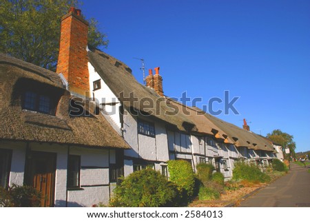 A row of whitewashed thatched cottages in a Buckinghamshire village