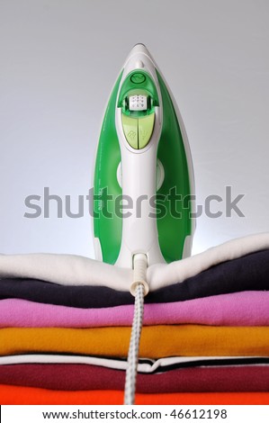 Stack of ironed clothes with iron