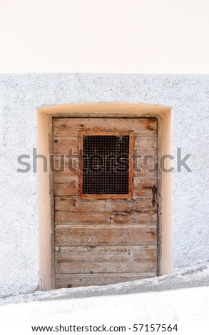 old wooden door below street level with a small window