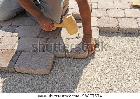 man at work paving stones with rectangular