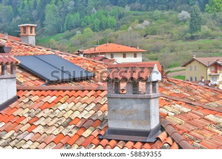 solar panels, roof tiles and fireplaces for heating, background mountain forest