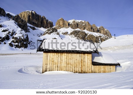 lodges on the snow on the Italian Dolomites, Val di Fassa with blue sky background