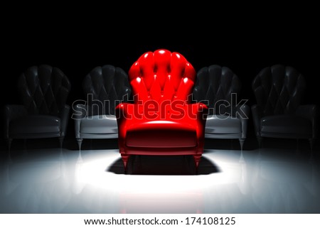Red armchair illuminated in front of camera with gray armchairs behind it