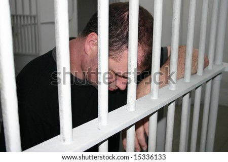 Despondent man in prison behind bars