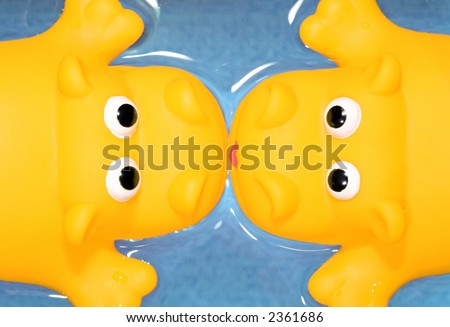 couple of yellow toy hippos kissing on a valentine\'s date