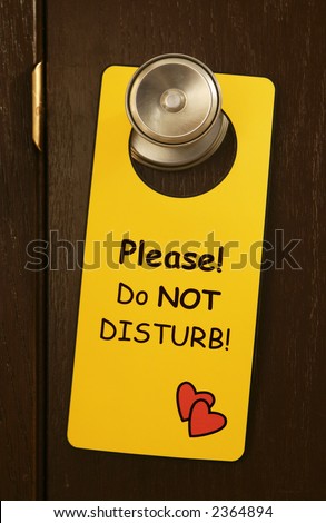 a fun yellow DO NOT DISTURB sign on a door knob