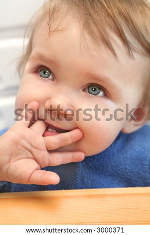 adorable teary eyed baby sucking his / her finger with the little palm of the hand showing
