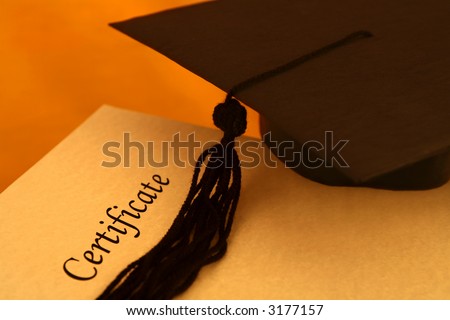 certificate printed on a yellowish grainy textured paper and a black graduation cap, on yellow - orange background