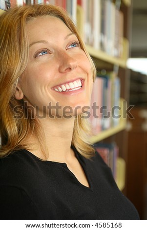 attractive female university student in the library dreaming of a bright future that her education will allow