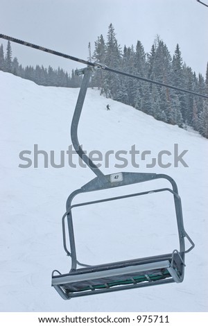 A single ski lift chair on a snowy day