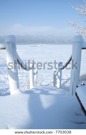 Stairs covered in snow to the beach