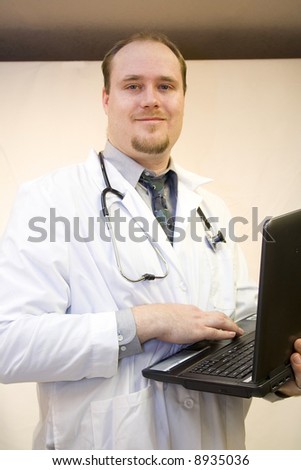 Young doctor with laptop smiling