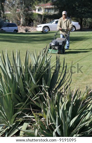 Man mowing lawn at upscale home