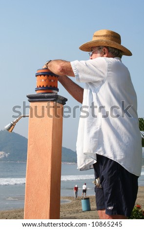 man changing light bulb in beachfront lamp