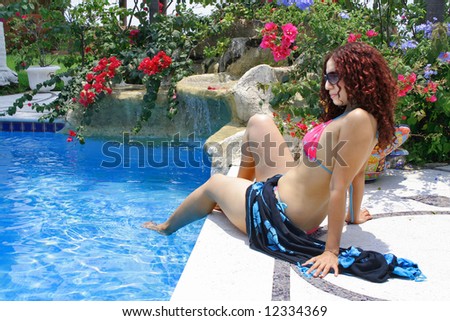Beautiful young woman poolside enjoying cool water and sunshine
