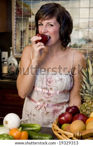 A pretty young woman taking a bite out of an apple