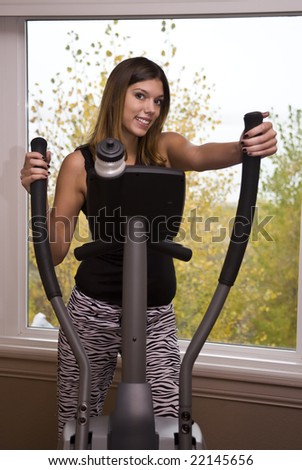 Young woman working out on an elliptical machine