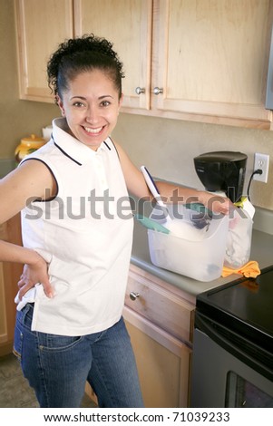 Young hispanic woman with cleaning bucket and tools in kitchen smiling