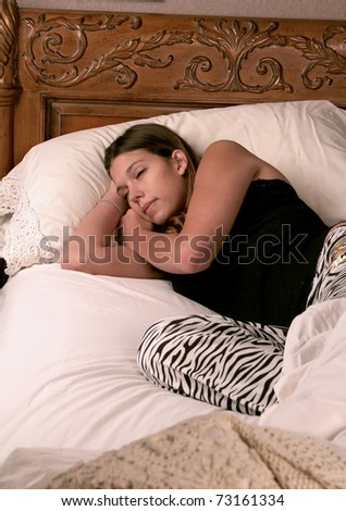 young woman asleep in her bed in pajamas