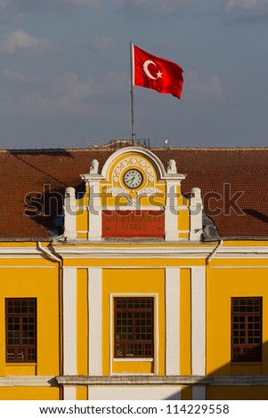 ISTANBUL - JULY 29: Clock, flag at the top of Galatasaray High School on July 29, 2012 in Istanbul, Turkey. Galatasaray School established in 1481, it is the oldest Turkish high school in the world.