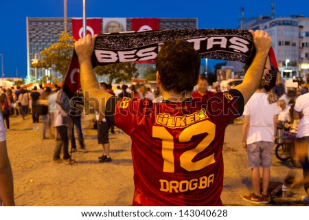 ISTANBUL - JUNE 19: Man with Galatasaray uniform lift up Besiktas scarf on June 19, 2013 in Istanbul, Turkey. Protests united opposing team supporters in Turkey.