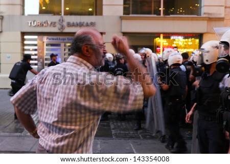 ISTANBUL - JUNE 22: Man try to stop police intervention in Istiklal Street on June 22, 2013 in Istanbul, Turkey. People came Taksim Square with carnations to commemoration for dead during protests