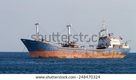 A Rusty Cargo Ship is anchored in Sea