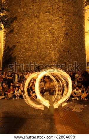 ISTANBUL, TURKEY - SEPTEMBER 18: A street performer spins fire during street shows in Galata square on September 18, 2010 in Istanbul, Turkey