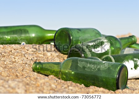 Close-up of empty green glass bottles, dumped on a rocky ground. South Sinai, Egypt.