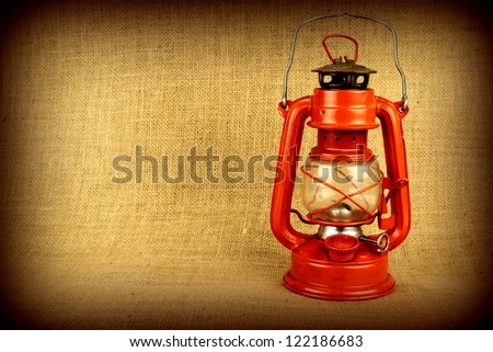 Red oil lamp on burlap and copy space