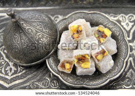 Turkish delight with pistachio nuts in traditional carved patterned metal plate